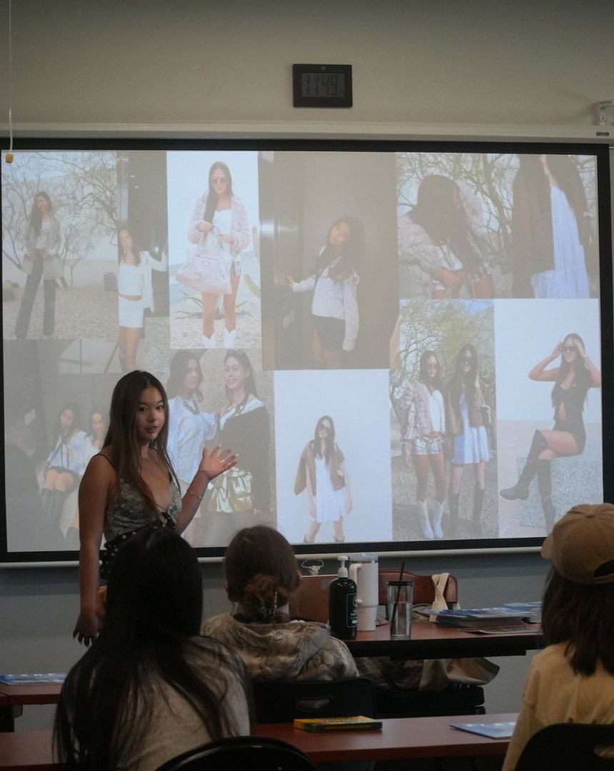 A presenter speaking in front of a projected photo collage